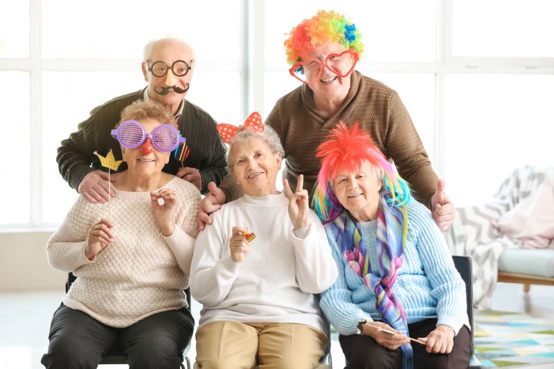 Group of older people wearing funny masks and wigs for a party